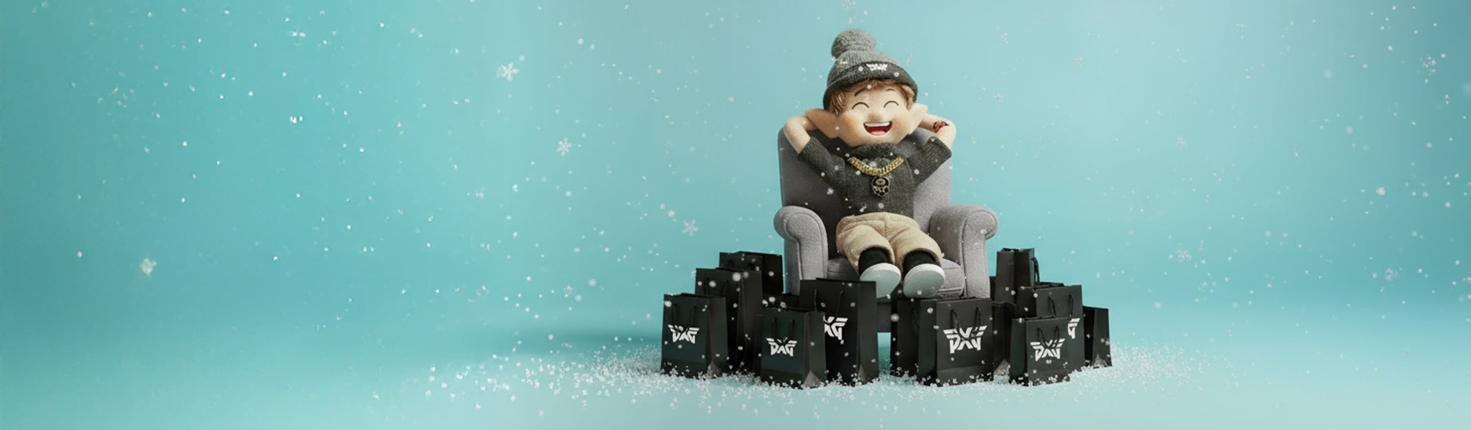 Small child in a gray coat sitting on black boxes with snowflakes falling against a light blue background
