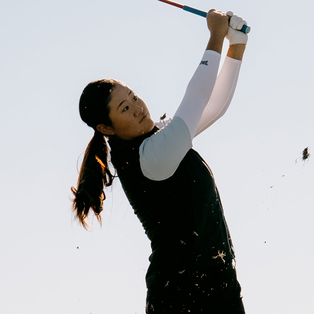 LPGA Tour Pro Gina Kim swinging a golf club against the white sky.