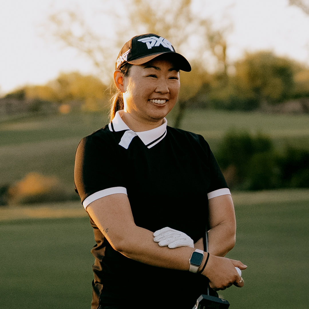 LPGA Tour Pro Mina Harigae wearing a PXG Golf Hat on a golf course.