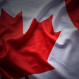 Close-up of a waving Canadian flag with a prominent red maple leaf.